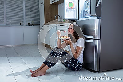 Woman Enjoy Eating Sweet Food In Kitchen Stock Photo