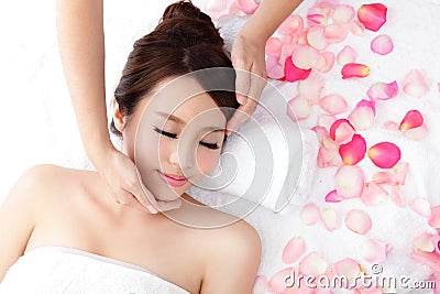 Woman enjoy receiving face massage at spa with roses Stock Photo