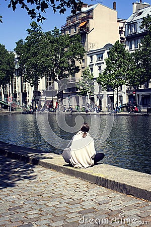 Woman enjoy sunny weather by canal Saint-Martin Editorial Stock Photo