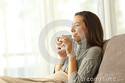 Woman enjoying a cup of coffee in winter at home Stock Photo