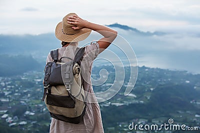 Woman enjoying sunrise from a top of mountain Batur, Bali, Indonesia Stock Photo