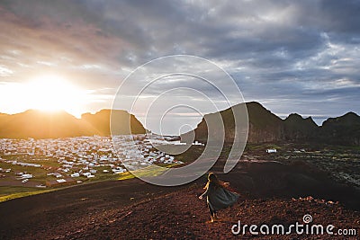 Woman enjoying sunset on peak Eldfell volcano with view of Vestmannaeyjar island Stock Photo