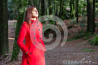 Woman enjoying the warmth of the winter sunlight on a forest Stock Photo