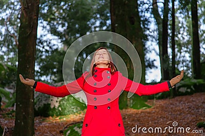 Woman enjoying the warmth of the winter sunlight on a forest Stock Photo