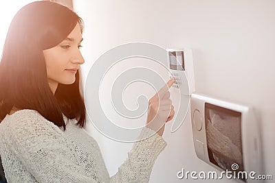 Woman entering code on keypad of home security alarm Stock Photo