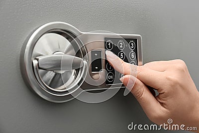 Woman entering code on keypad of safe, closeup Stock Photo