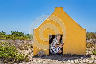 Woman entering yellow slave house at coast Stock Photo