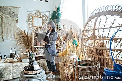 woman entrepreneur using a laptop among exotic handicrafts Stock Photo