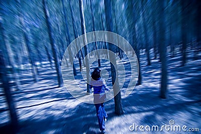 Woman escaping through the woods Stock Photo