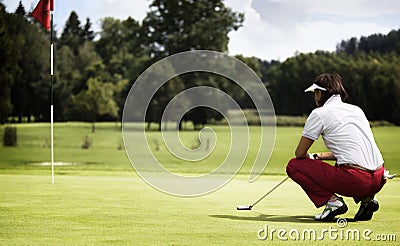 Woman examining green before putting. Stock Photo