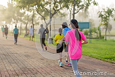 Woman exercise jogging in park with blurred people in background. Editorial Stock Photo
