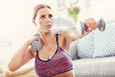 Woman exercising with dumbbells at home Stock Photo