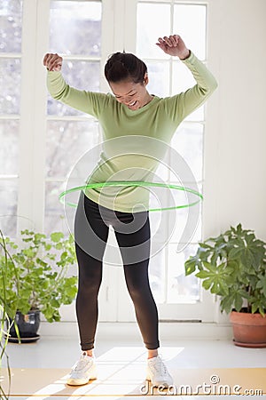 Woman exercising with hula hoop Stock Photo