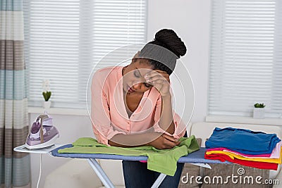 Woman Exhausted While Ironing Clothes Stock Photo