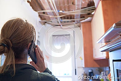 Woman explaining a kitchen ceiling incident to her homeowner`s insurance company Stock Photo