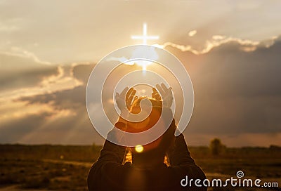 The woman extends her hand to the cross Stock Photo
