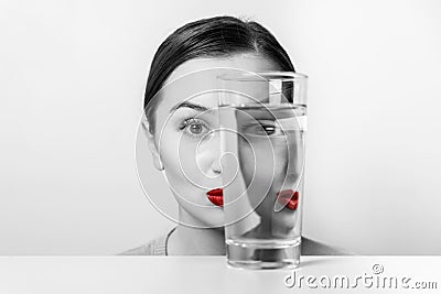 Woman Face Distortion In Water Glass Stock Photo