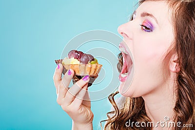 Woman face profile open mouth eating cake Stock Photo