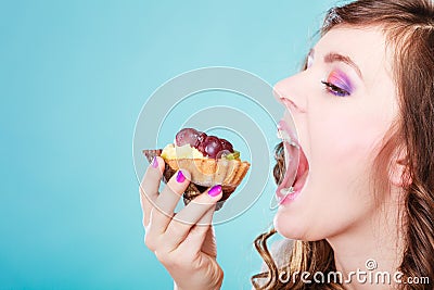 Woman face profile open mouth eating cake Stock Photo