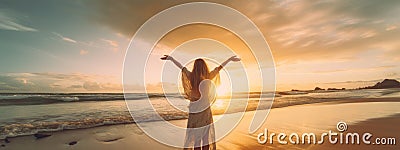 Woman facing the sunset with her hands up standing on a sea beach Stock Photo