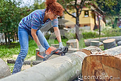 Woman farmer using the chainsaw Stock Photo