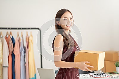 Woman fashion designer standing and holding cardboard box Stock Photo