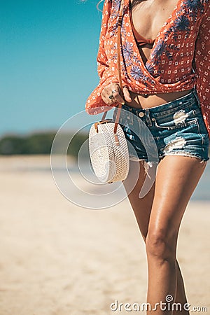 Woman with fashionable stylish rattan bag and silk scarf outside. Tropical island of Bali, Indonesia. Rattan handbag and Stock Photo