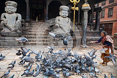 Woman feeding pigeons Editorial Stock Photo