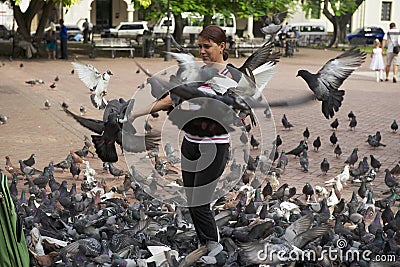 Woman feeds pigeons in Santo Domingo, Dominican Republic. Editorial Stock Photo