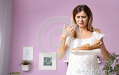 Woman feeling bad smell from shoes at home Stock Photo