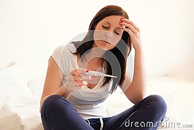 Woman feeling depressed and sad after looking at pregnancy test Stock Photo