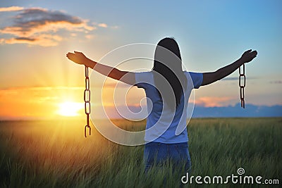 Woman feeling free in a beautiful natural setting, in what field at sunset. Free from chains Stock Photo