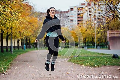 Woman feet jumping, using skipping rope in park. Stock Photo