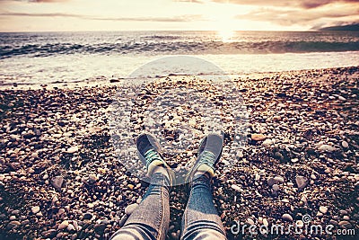 Woman Feet sneakers on beach sea sunset Stock Photo