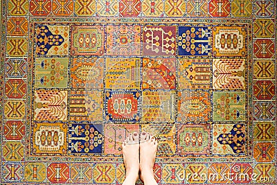 Woman Feet Standing on Vintage Carpet Stock Photo