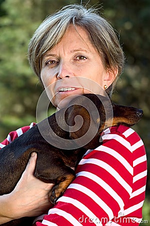 Woman in fifties holding a dog Stock Photo