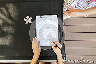 Woman fill visa application in travel agency. close up hands, pe Stock Photo