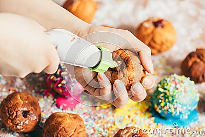 Woman filling homemade doughnut with red jam Stock Photo