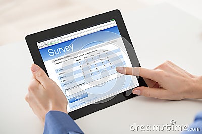 Woman Filling Online Survey Form On Digital Tablet Stock Photo