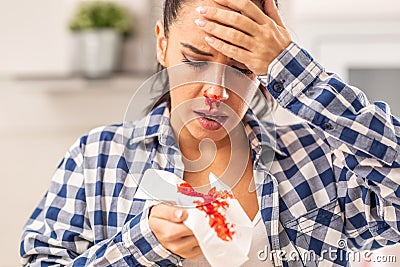 Woman find out her nose is bleeding after sneezing into a tissue Stock Photo