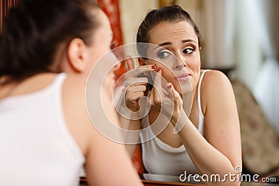 Woman finding an acne on her cheek Stock Photo