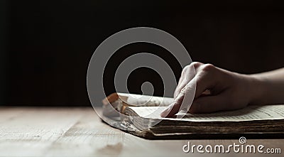 Woman finger presses on old bible book Stock Photo