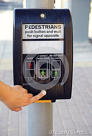 Woman finger pushing pedestrians button to cross the street Stock Photo