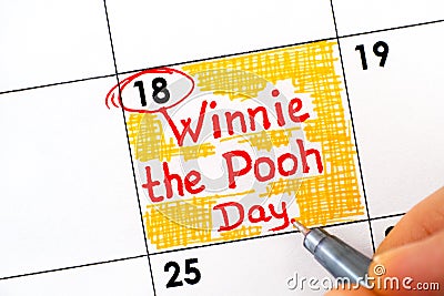 Woman fingers with pen writing reminder Winnie the Pooh Day in calendar Editorial Stock Photo