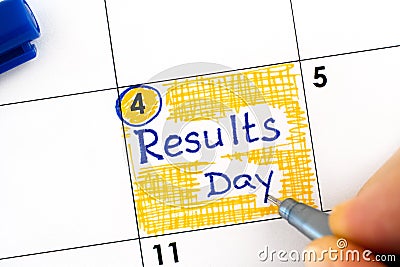 Woman fingers with pen writitng reminder Results Day in calendar Stock Photo