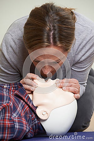 Woman In First Aid Class Performing Mouth To Mouth Resuscitation Stock Photo