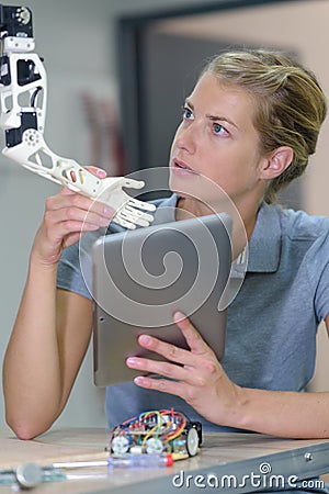 Woman fixing robotic arm Stock Photo