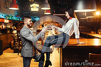 Woman flirting with man, couple at bar counter Stock Photo