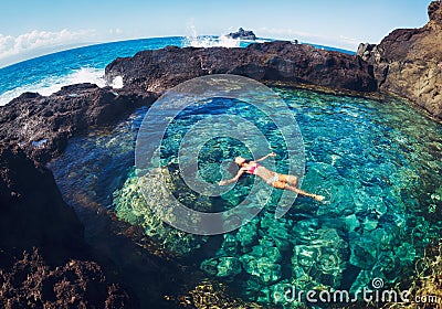 Woman floating in natural pool Stock Photo