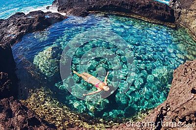 Woman floating in natural pool Stock Photo